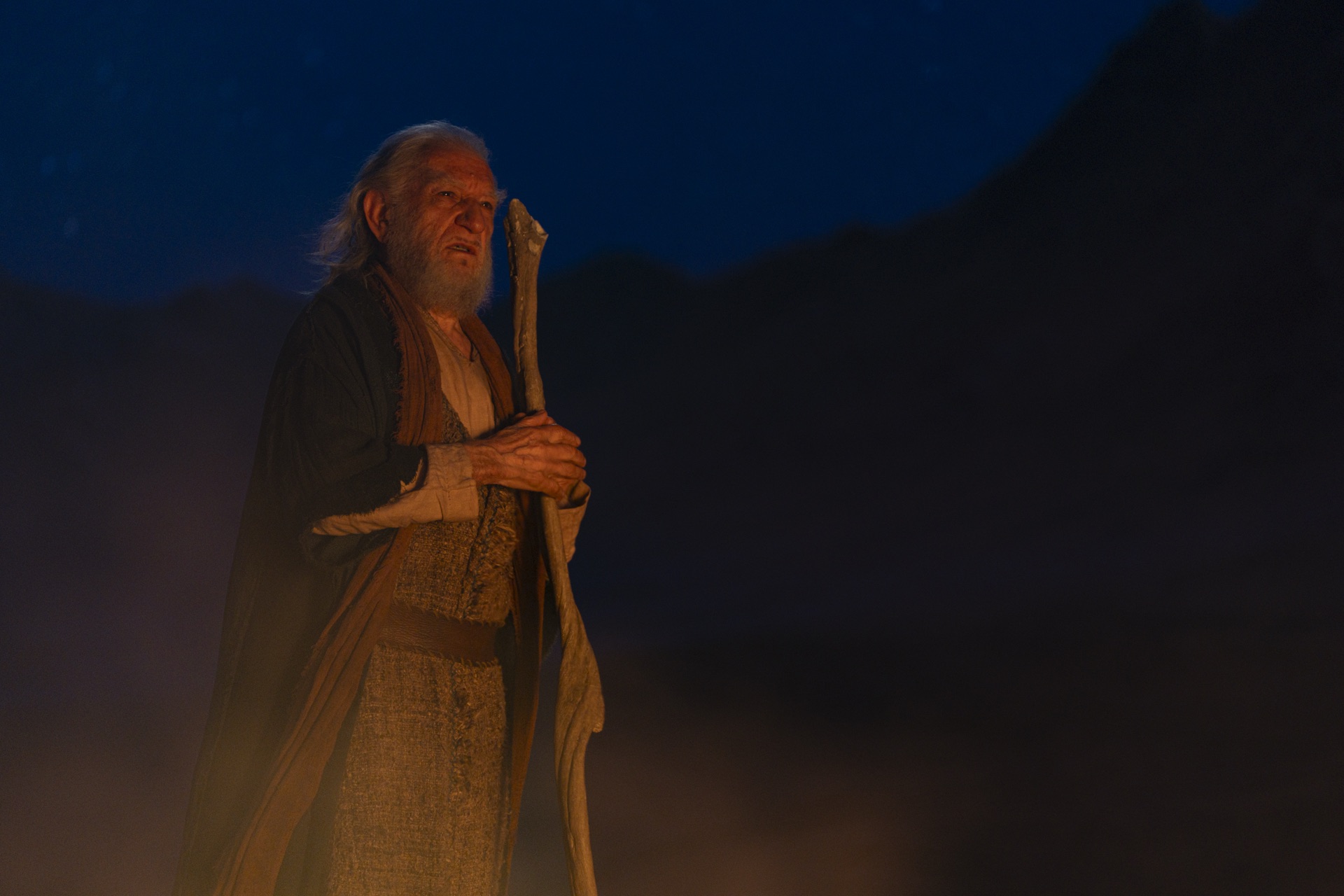 Moses stands in the desert at night, holding his shepherd's staff